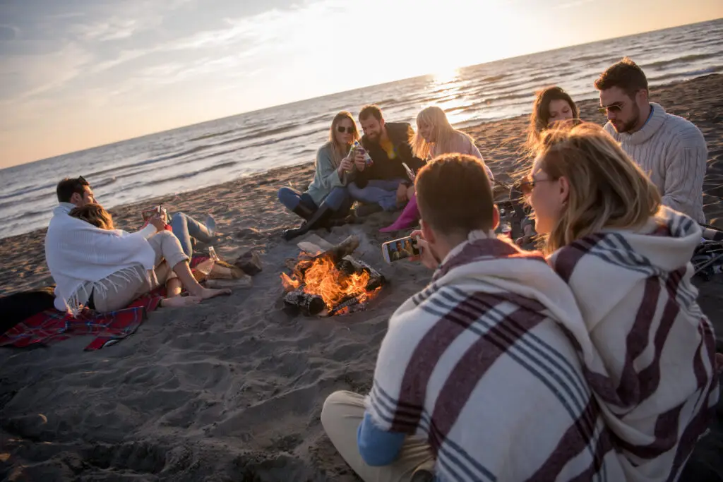 Happy People sitting by beach fire
