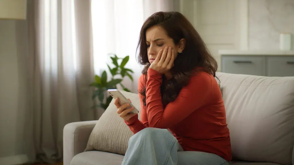 Woman contemplating what is on her phone