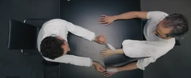 Overhead view of two people at a table representing thought, perspective, and the power of the mind.